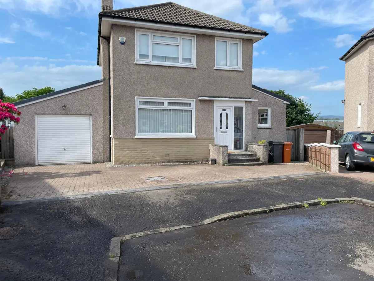 The same Bearsden driveway after: the wall removed and the drive joined to the street with a charcoal monoblock border