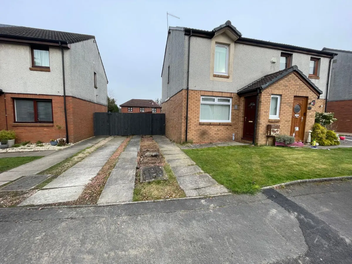 Cumbernauld driveway before the work: two strips of concrete slabs with red chuckies between them